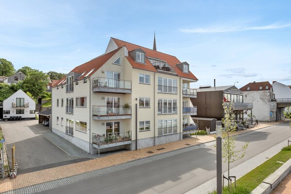 A multi-story building with balconies, a parking area, and a street view. - Harbour Penthouse (Sønderborg)