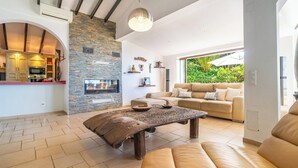 A modern living room with a stone wall, a fireplace, a sofa, and a coffee table.