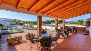 An outdoor patio with a pool, surrounded by brick pillars and wooden beams, featuring outdoor furniture and a clear view of the landscape. - Casa Rural Embalse Bermejales Arenas del Rey by Ruralidays (Granada)