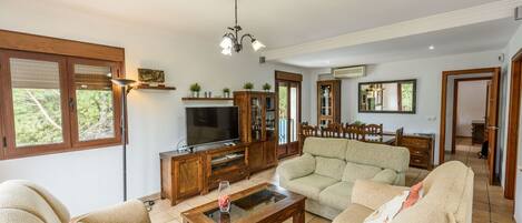 A spacious living room with a sofa set, a coffee table, a TV, and a wooden cabinet.