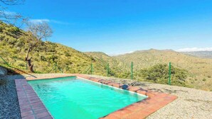A swimming pool with a clear view of the surrounding hills and mountains.