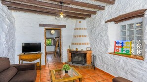 Una sala de estar acogedora con chimenea, televisor y una mesa de centro.