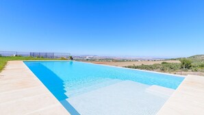 A rectangular swimming pool with clear blue water, surrounded by a light-colored deck. - Finca Las Encinillas Arcos de la Frontera by Ruralidays (Cádiz)
