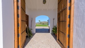 A doorway leading to a covered outdoor area with a view of a hill and a clear sky. - Finca Las Encinillas Arcos de la Frontera by Ruralidays (Cádiz)