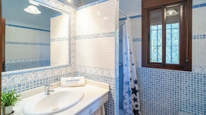 Un baño con lavamanos, espejo y cortina de ducha con motivos de estrellas.