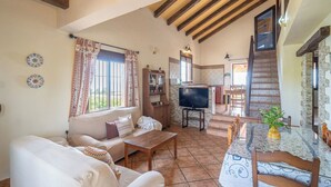 Una sala de estar acogedora con sofá, televisor y mesa de comedor.