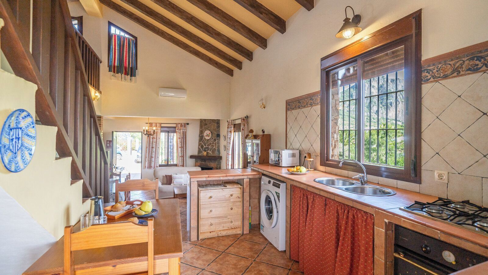 A kitchen with a washing machine, a sink, and a stove.