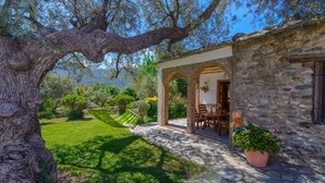 A stone building with a garden and a hammock. - Cortijo Las Pitas Órgiva by Ruralidays (Granada)