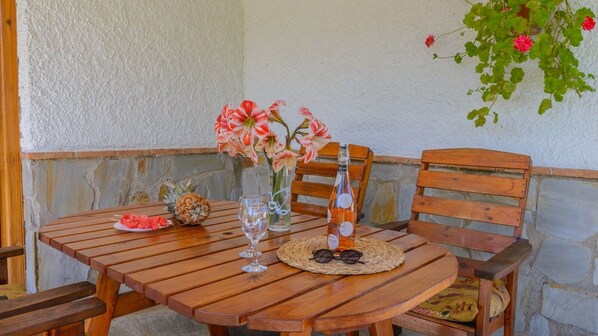 A wooden table with a pineapple, a glass, a bottle, and a vase with flowers. - Cortijo Las Pitas Órgiva by Ruralidays (Granada)