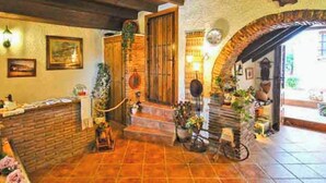 A rustic interior with a brick wall, wooden door, and a tiled floor.