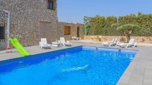 A swimming pool with a stone wall and a green slide. - Alojamiento Rural Soler Pozo Alcón by Ruralidays (Jaén)