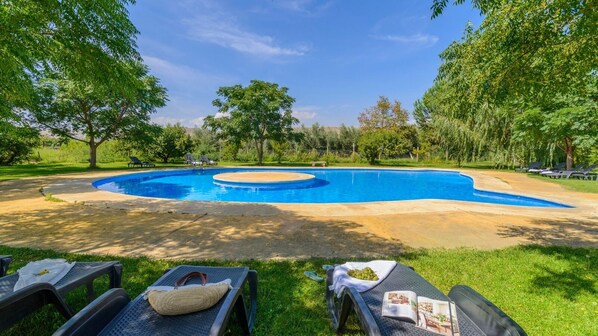 A swimming pool with a circular hot tub, surrounded by grass and trees. - Cuevas La Chumbera - Cerezos 2pax Fonelas by Ruralidays (Granada)
