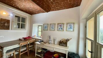 A kitchen with a wooden table, chairs, a white counter, and framed artwork on the wall.