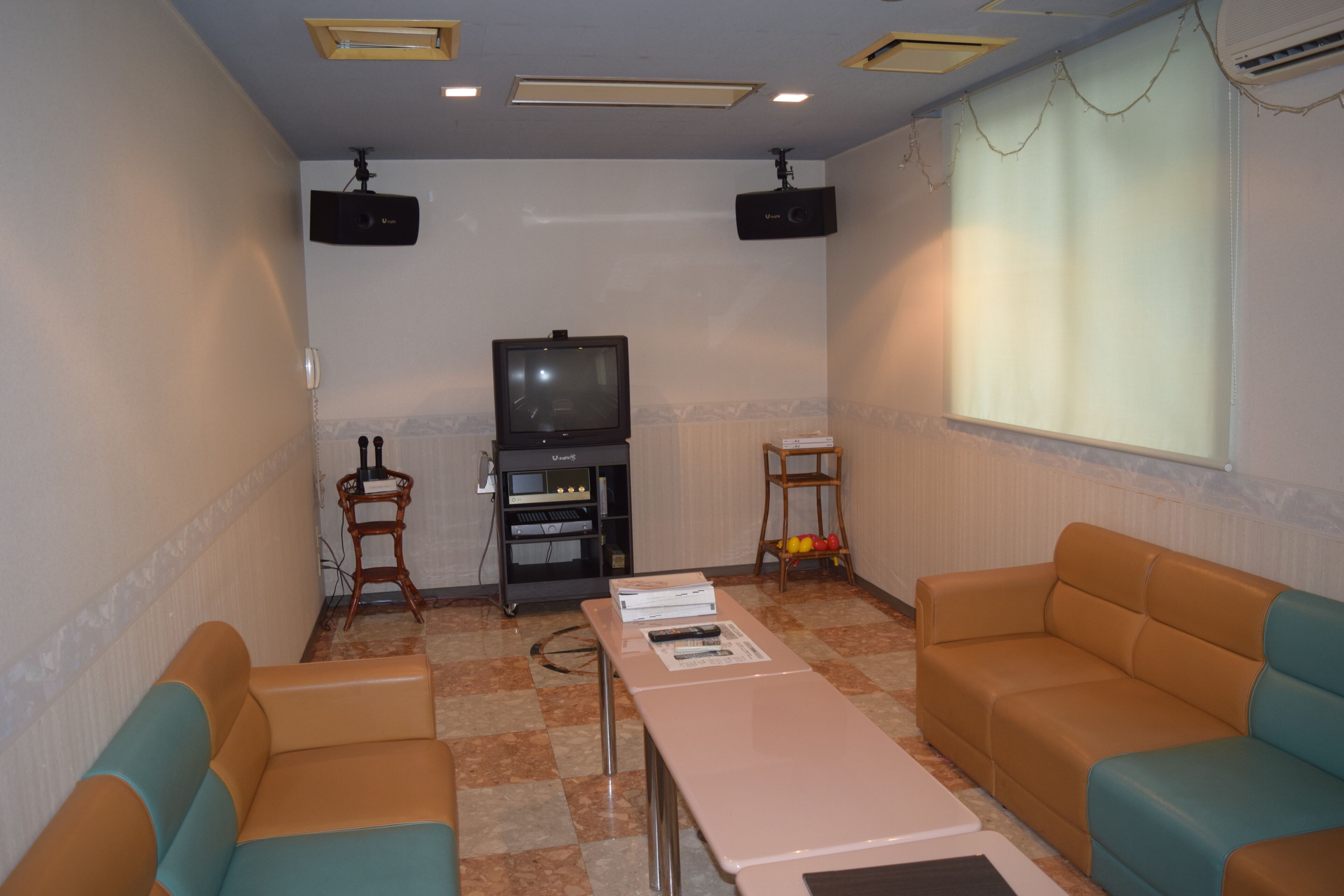 A room with a television, two sofas, a table, and a speaker system.