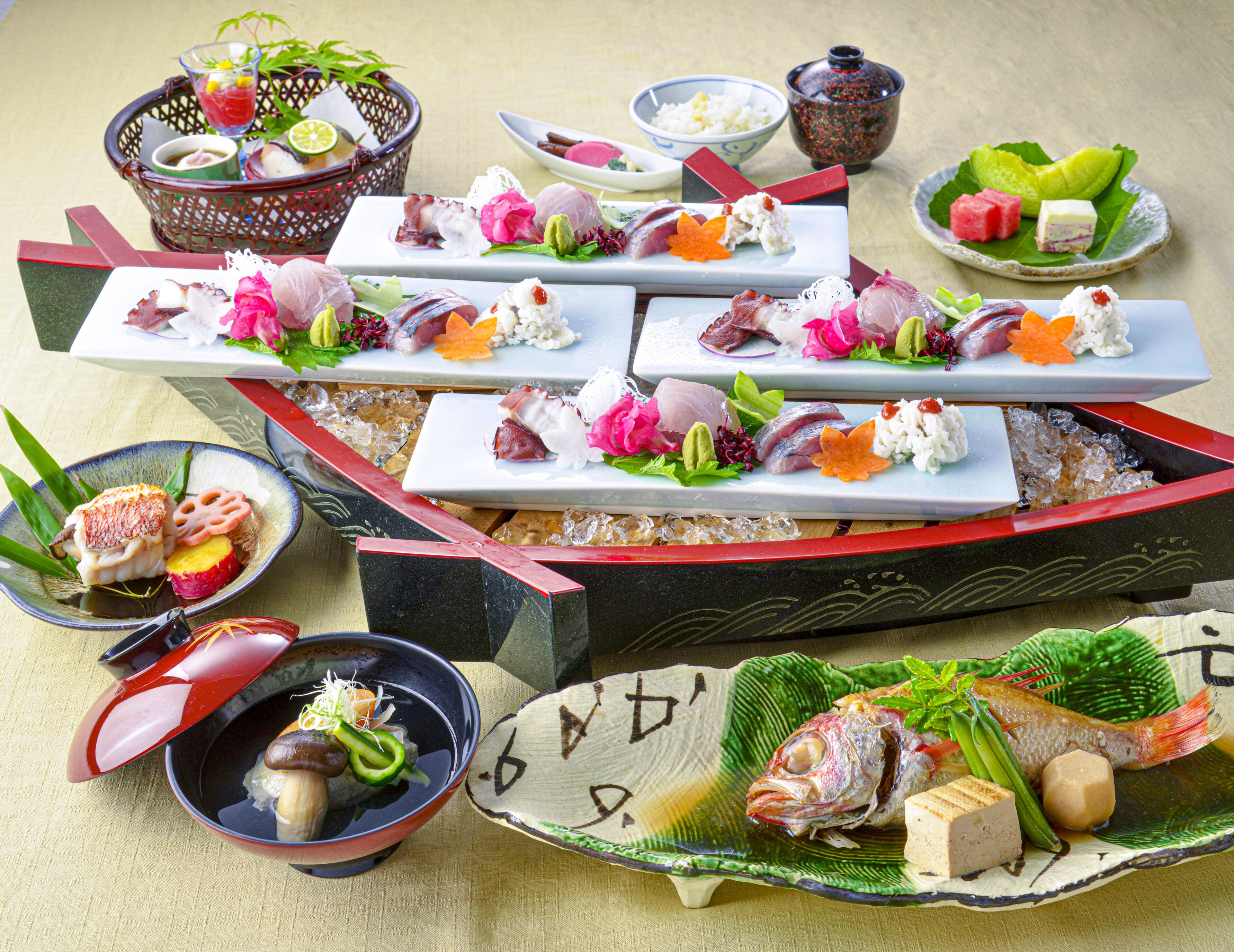 Variedad de platos de sushi sobre una mesa, incluyendo sashimi, nigiri y rollos, acompañados de recipientes pequeños con salsas y verduras encurtidas.