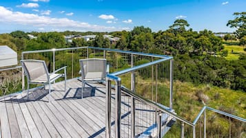 Guests can enjoy the serene views from this outdoor deck, featuring two comfortable chairs.