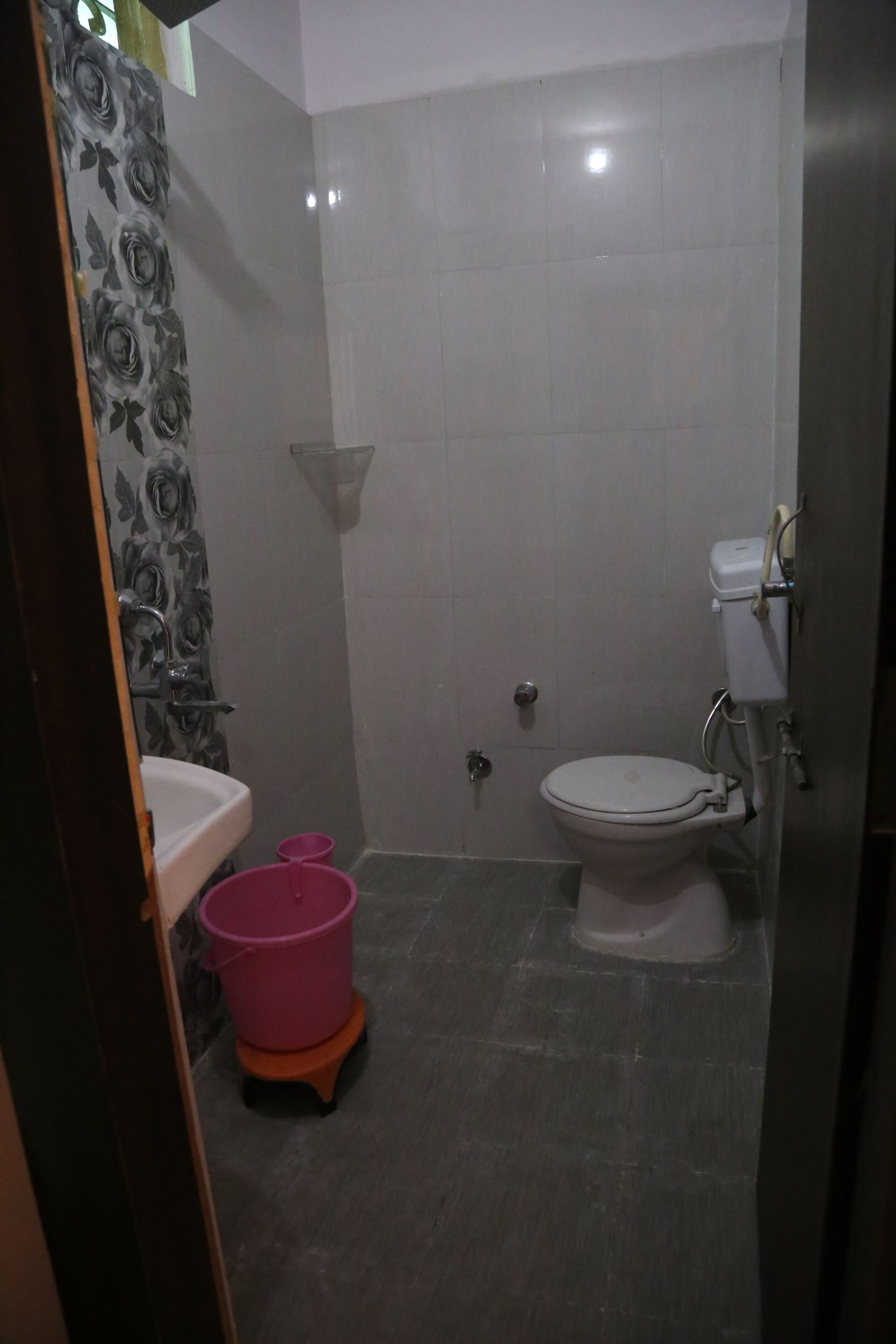 A small bathroom with a toilet, sink, and a shower area.