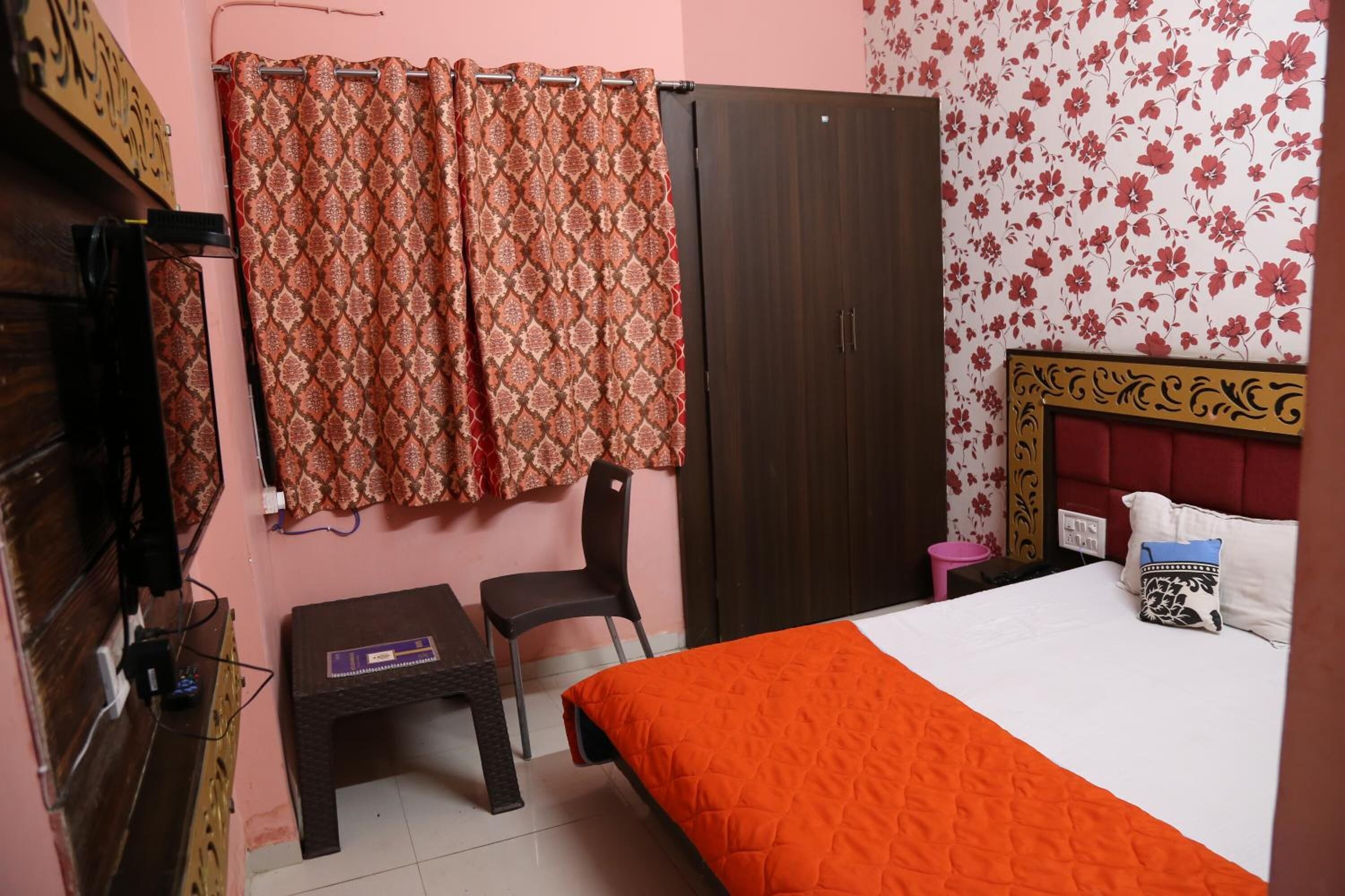 Une chambre à coucher avec un lit, une chaise, un bureau, une armoire et un rideau.