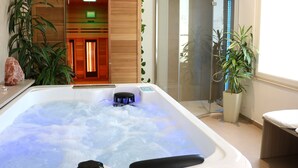 A spa room with a hot tub, a massage chair, and a sauna.