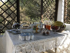 A table set with breakfast items, including fruits, beverages, and condiments, in a sunny outdoor setting. - La Vecchia Tabaccheria B&B (Ostuni)
