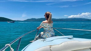 A person on a boat with a clear view of the sea and distant land. - Oimho Beach House Apartment Beach Front (Koh Samui)