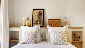 A neatly made bed with patterned pillows, a framed artwork, a wooden chest of drawers, and a small shelf with a horse figurine. - Newly renovated townhouse  w/ garden and sea-view for 4 guests in old Antibes (Antibes)