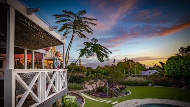 Un espace aménagé au bord de la piscine, avec une terrasse, une piscine et une vue sur le jardin et les arbres environnants.