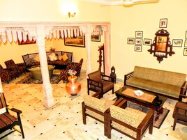 Un interior tradicional con sofás estampados, una mesa de centro y un jarrón decorativo.