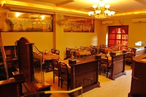 Ein Essbereich mit Holzzmöbeln, einer Chandelier und Kunstwerken an den Wänden.