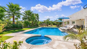 A rectangular swimming pool with a hot tub in the center, surrounded by palm trees and lounge chairs. - Palm View Ranch - 1 acre mini resort! (Palm Desert)