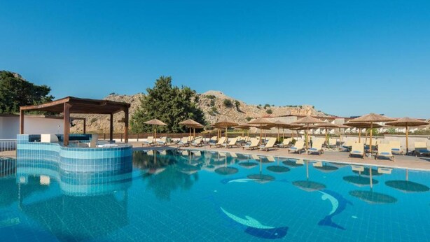 A swimming pool with lounge chairs and umbrellas, surrounded by a rocky landscape. - Anavadia Hotel By Anayia All Inclusive Resorts (Rhodes)