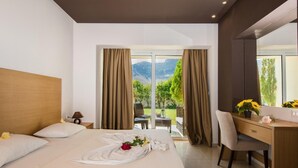 A hotel room with a bed, a desk, and a view of a mountainous landscape. - Anavadia Hotel By Anayia All Inclusive Resorts (Rhodes)