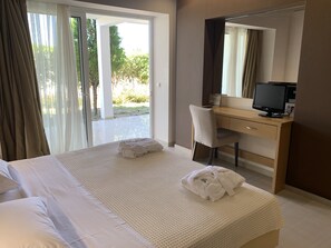 Relax in a spacious room with a large bed, desk, and sliding door leading to an outdoor area.