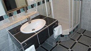 Un bagno con lavandino, specchio e doccia.