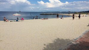 Une plage où des gens se prélassent au soleil et se baignent.