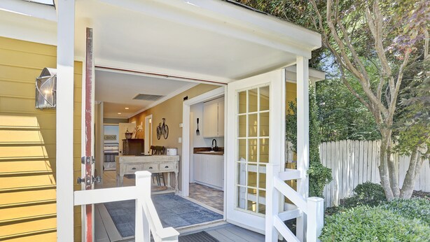 Une maison avec une véranda, une cuisine et un coin repas.