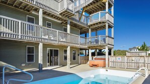 Un edificio de varios pisos con balcones, piscina y jacuzzi.