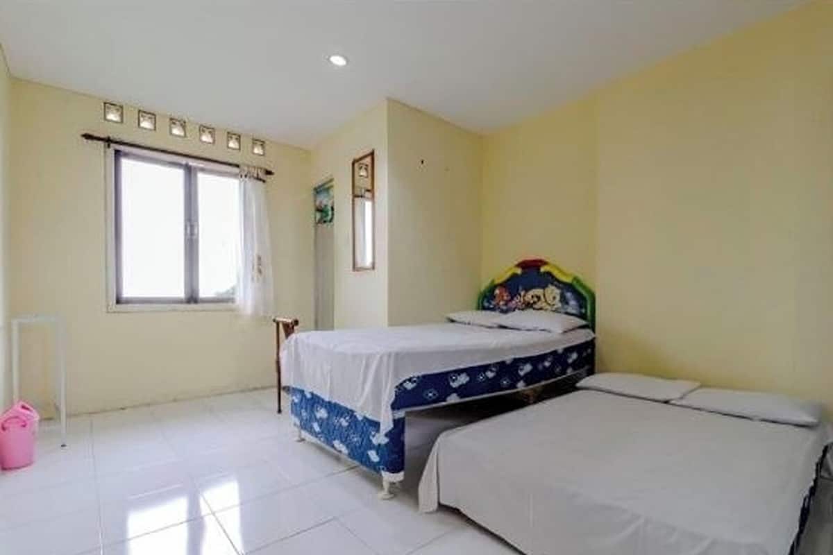 A bedroom with a bed, a window, and a door.