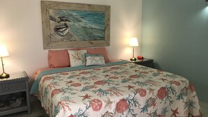 Une chambre à coucher avec un lit, deux lampes de chevet, une table de chevet, un tapis et un tableau mural.