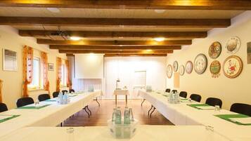 A conference room with a long table, chairs, and a projector screen.