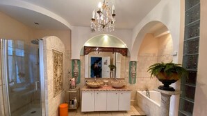 A luxurious bathroom with a glass-enclosed shower, a large vanity with ornate mirrors, and a freestanding bathtub. - Clos Germanois (Saint-Germain-Laval)