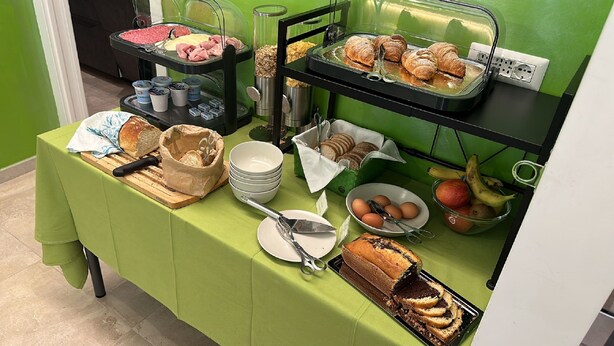En buffet med forskellige spisemuligheder, herunder brød, kager og frugt.