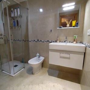 Een douche, een haardroger, een bidet, handdoeken