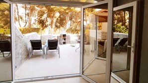 Un intérieur moderne avec une porte vitrée donnant sur un patio extérieur.