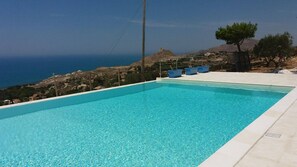 Una piscina al aire libre de temporada, sombrillas