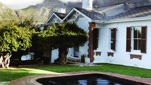 Uma casa com piscina, cercada por vegetação e montanhas.