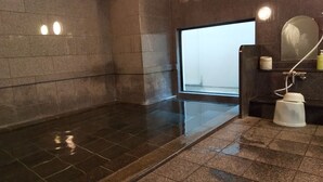 A wet, tiled floor with a large window, a mirror, and a white pedestal. - Hotel Route Inn Aomori Chuo Inter (Aomori)