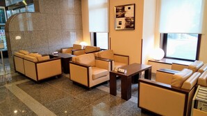 A lobby with seating areas, a reception desk, and a wall-mounted artwork. - Hotel Route Inn Aomori Chuo Inter (Aomori)