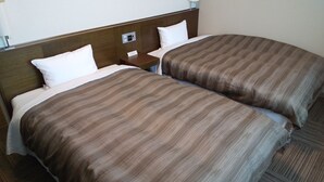 Two twin beds with brown striped bedding, a wooden headboard, a nightstand with a lamp, and a wall-mounted control panel. - Hotel Route Inn Aomori Chuo Inter (Aomori)