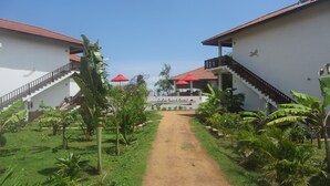 A pathway leading to a building with a sign reading "Ladja Beach Resort". - Ladja Beach Resort (Ambalantota)